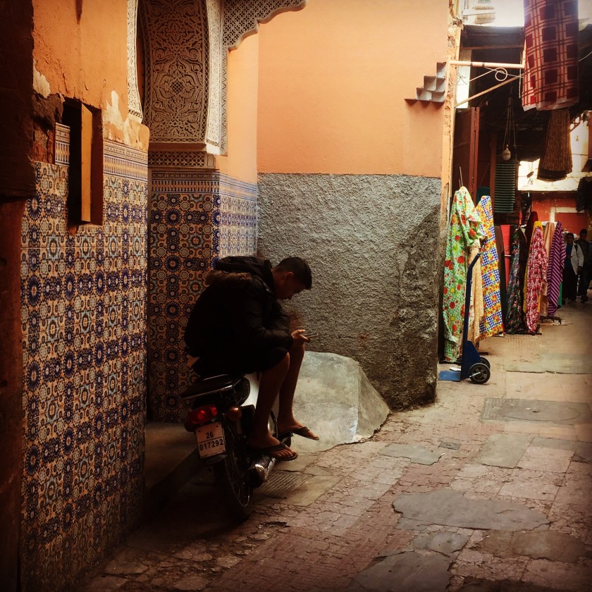 Moroccan boy on moped in souks 